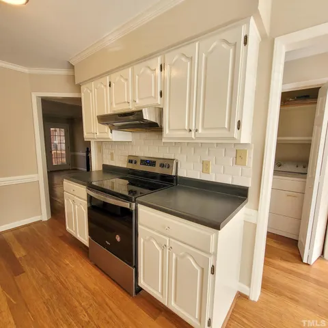 a kitchen with white cabinets and appliances