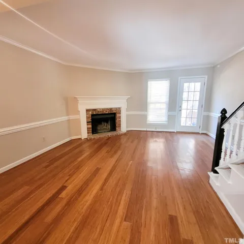 a view of empty room with wooden floor and fireplace