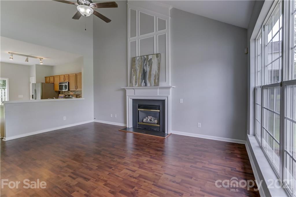 10208 Roundleaf Drive Charlotte, NC 28213 - Photo 4 of 26 an empty room with wooden floor fireplace and windows