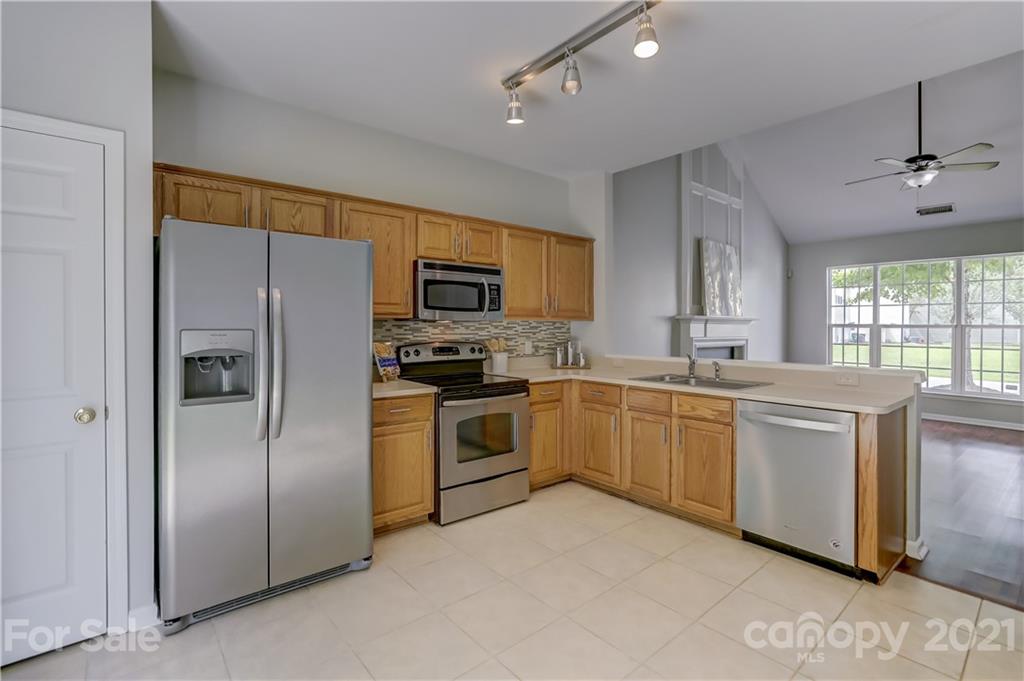 10208 Roundleaf Drive Charlotte, NC 28213 - Photo 8 of 26 a kitchen with cabinets stainless steel appliances and window