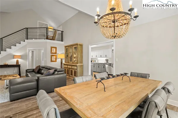 a living room with furniture a chandelier and a table