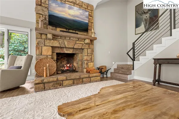 a living room with furniture a fireplace and a flat screen tv