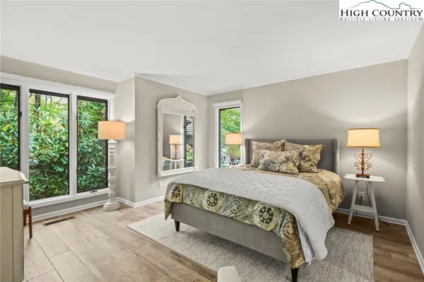 a bedroom with a bed lamp and a large window