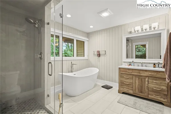 a spacious bathroom with a double vanity sink a mirror and a bathtub