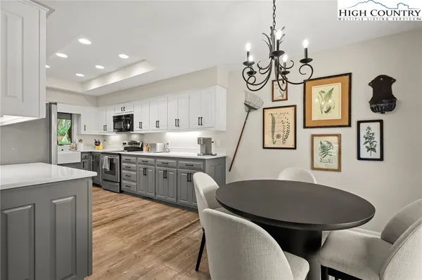 a kitchen with stainless steel appliances granite countertop a kitchen island hardwood floor sink stove dining table and chairs
