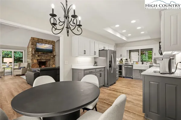 a large kitchen with a table chairs stainless steel appliances and cabinets