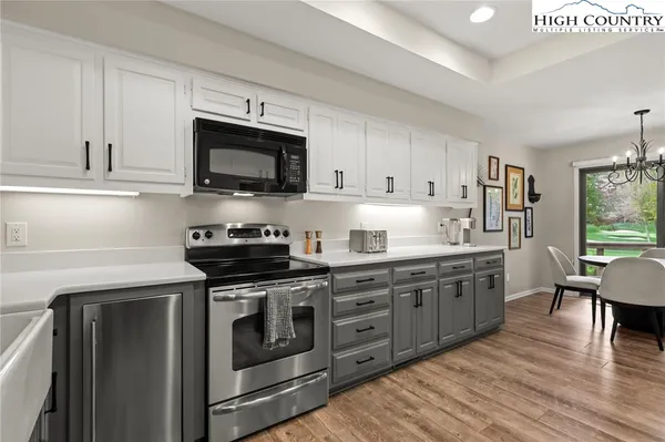 a kitchen with stainless steel appliances granite countertop a stove a sink and a microwave
