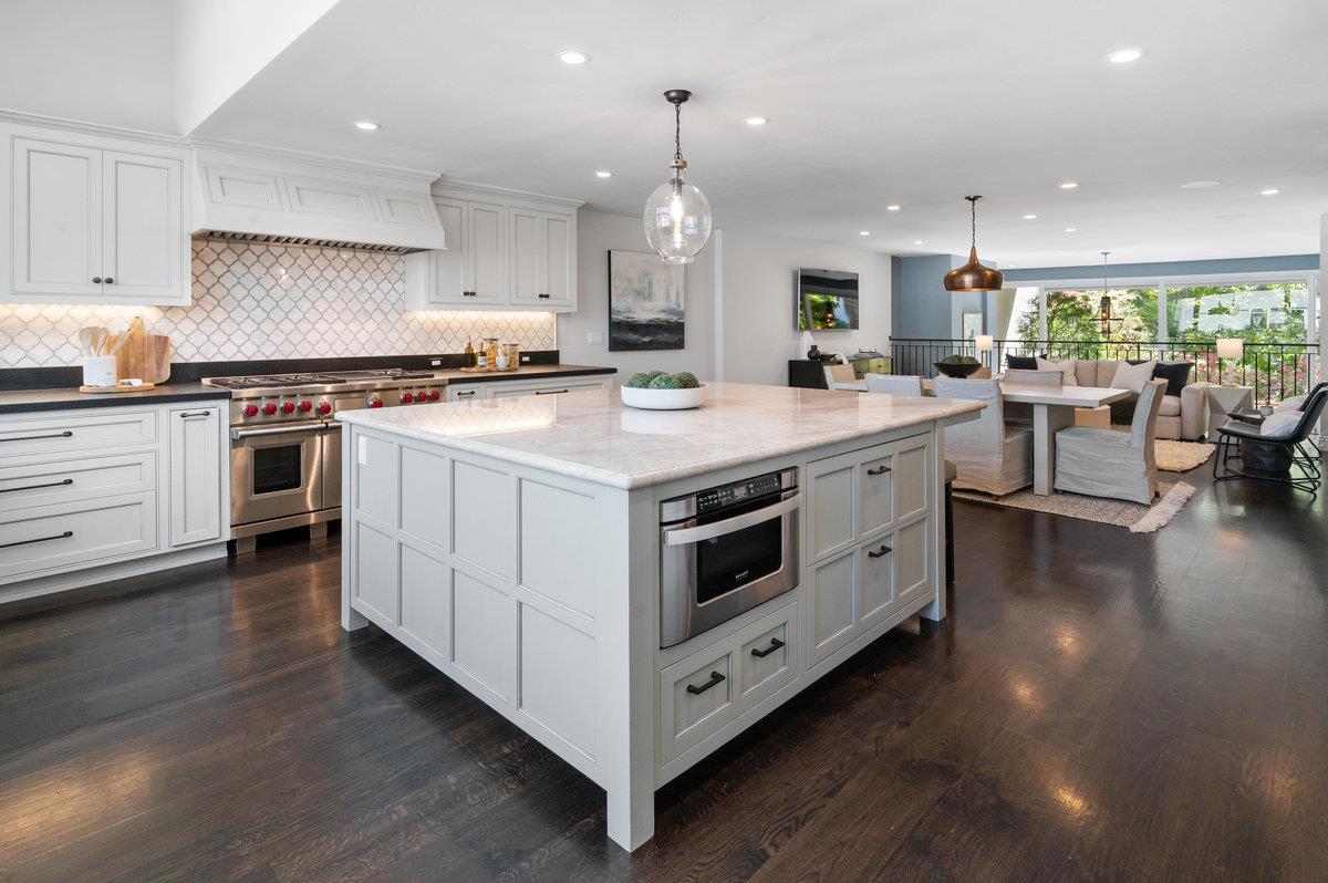 a large white kitchen with lots of counter space a sink and appliances