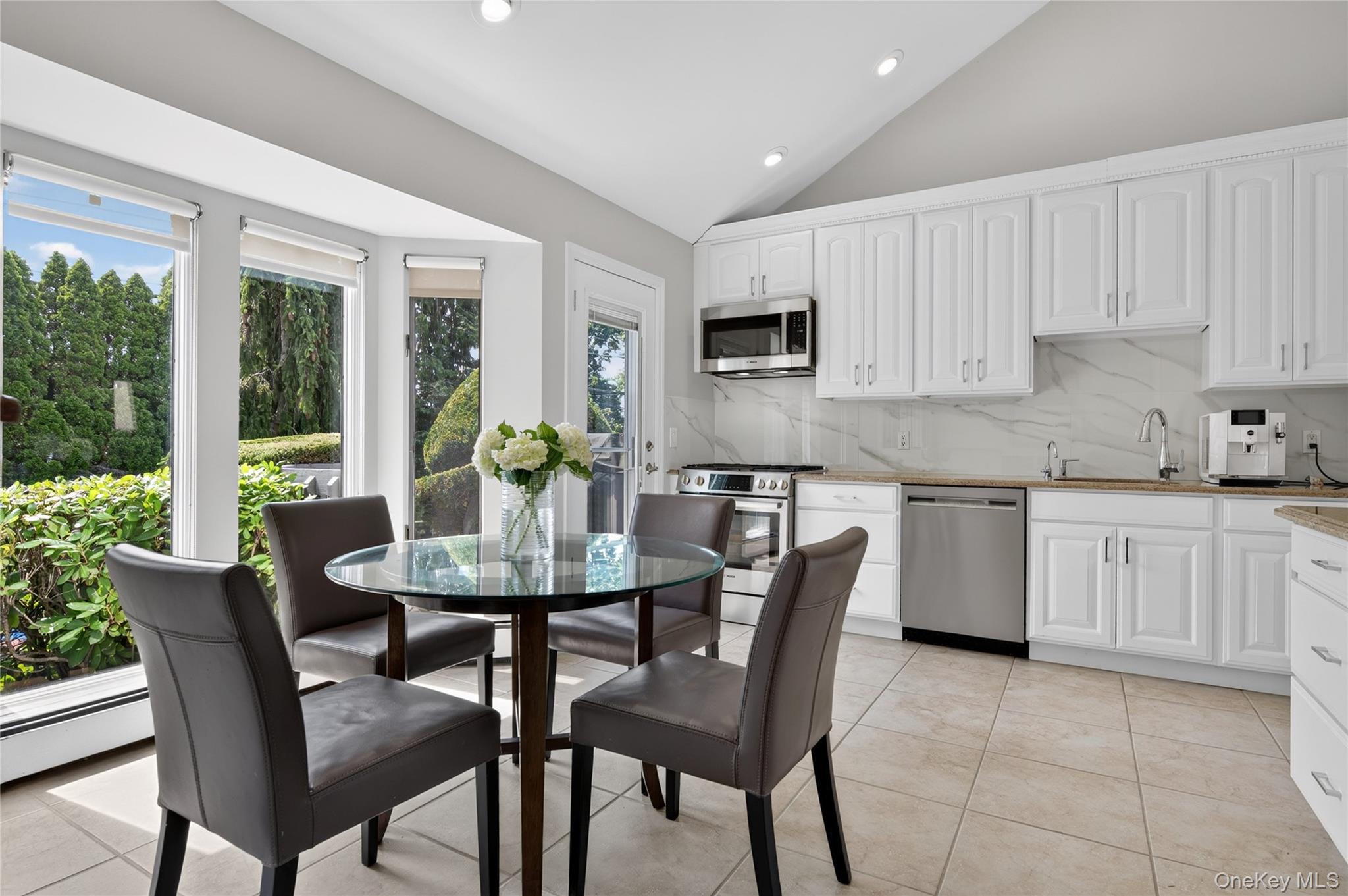 11 Sunbeam Road Syosset, NY 11791 - Photo 9 of 28 Kitchen featuring GAS stove, white cabinetry, stainless steel appliances, natural granite countertops, and tile flooring