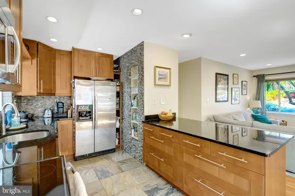 a kitchen with granite countertop a refrigerator and a stove top oven