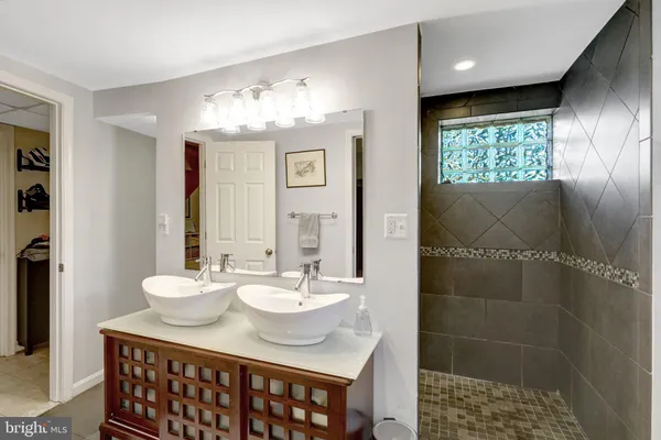 a bathroom with a sink shower and a mirror