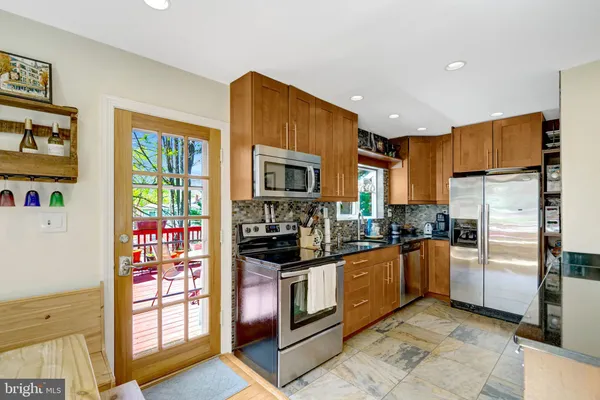 a kitchen with stainless steel appliances granite countertop a refrigerator and a stove top oven