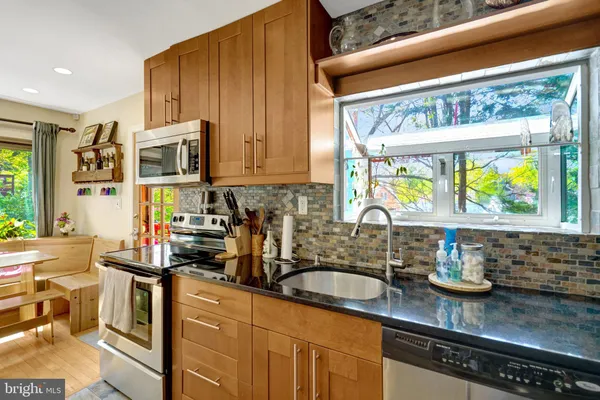 a kitchen with stainless steel appliances a sink a stove and a wooden cabinets