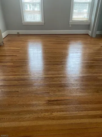 a view of a room with wooden floor and windows