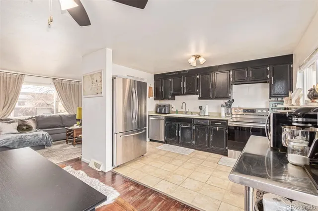 a kitchen with stainless steel appliances granite countertop a refrigerator sink and stove