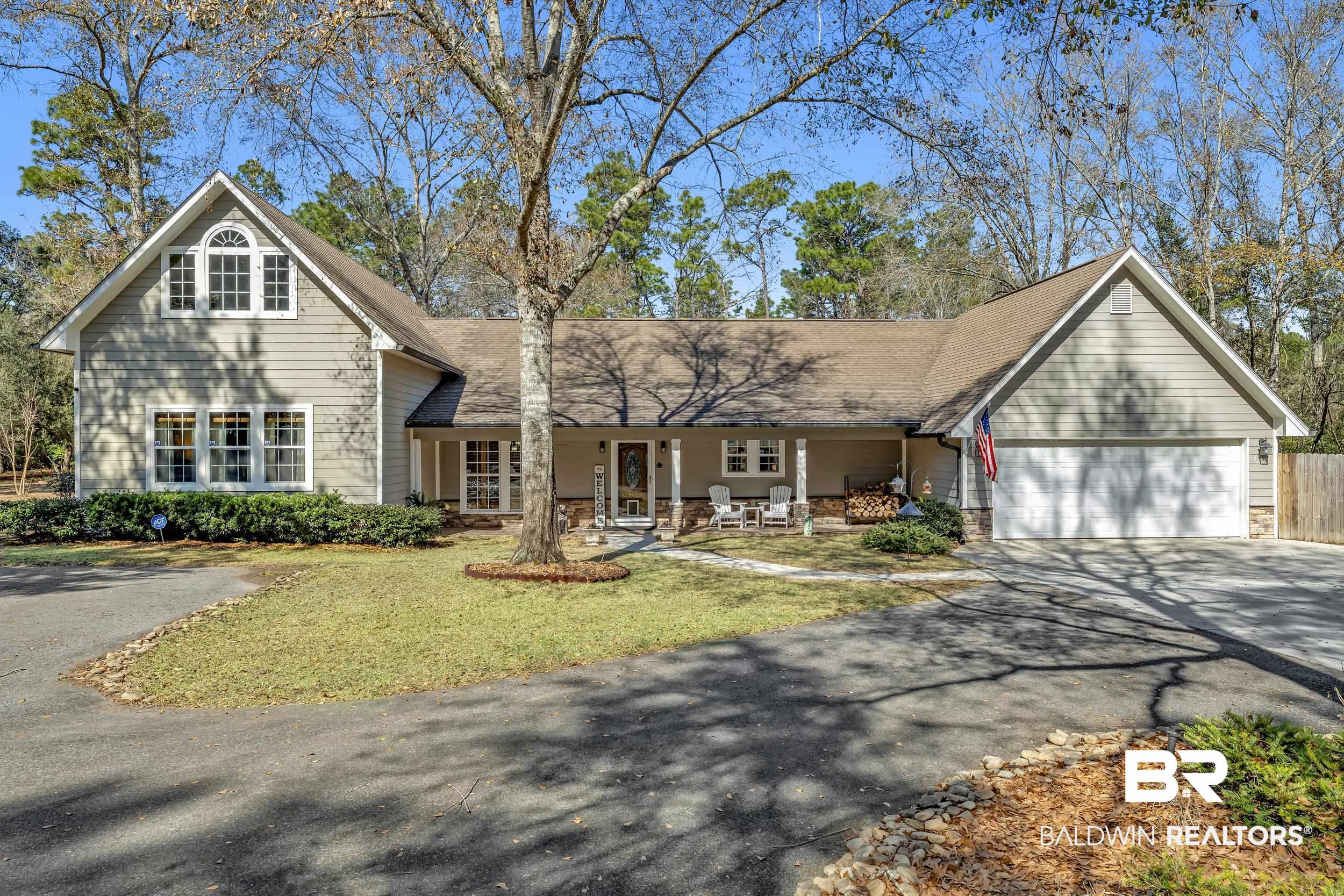 22929 Highway 98 Foley, AL 36535 - Photo 36 of 54 Traditional-style home featuring a porch, asphalt driveway, a garage, a front yard, and stone siding