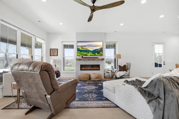 a living room with furniture a flat screen tv and a large window