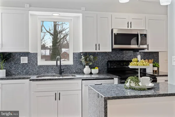 a kitchen with a granite counter top a stove a sink and a granite counter tops