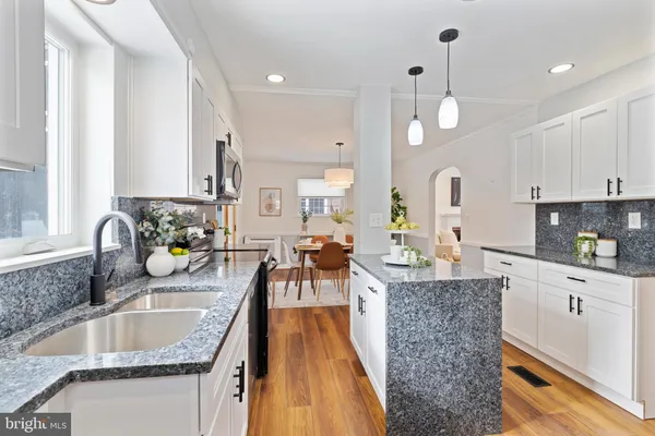 a large kitchen with granite countertop a lot of counter space and a sink