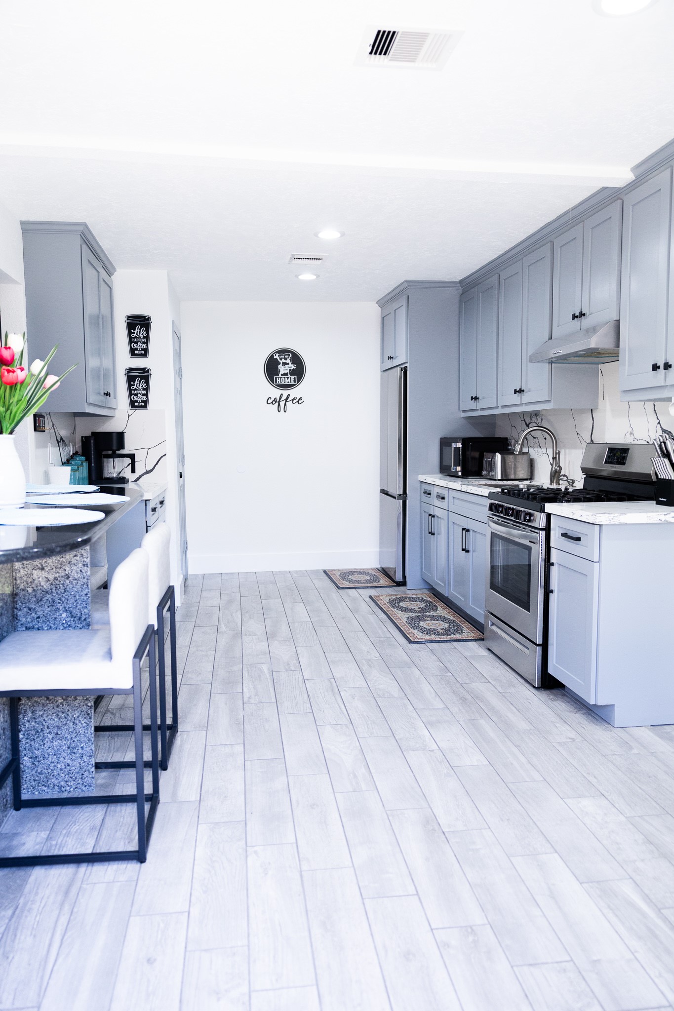 10463 Alcott Drive, Unit B Houston, TX 77043 - Photo 4 of 11 a kitchen with granite countertop a stove top oven a sink dishwasher and cabinets with wooden floor