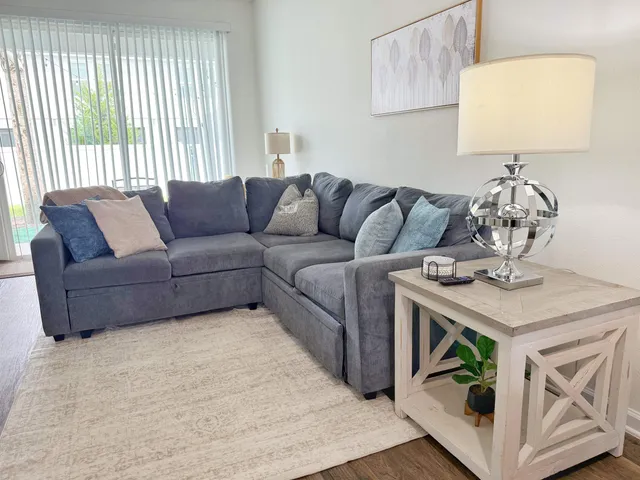 a living room with furniture and a wooden floor