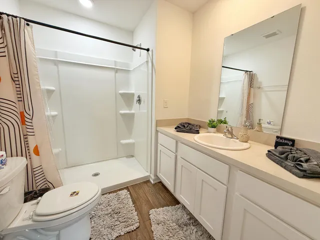 a bathroom with a granite countertop sink toilet and shower