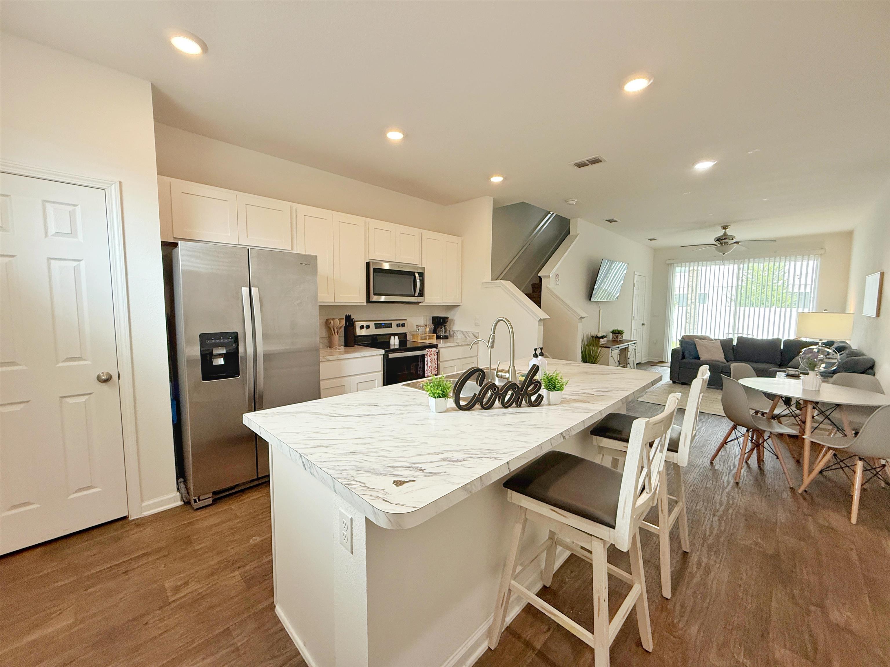 98 Vidalia Ridge Rd Street St. Augustine, FL 32084 - Photo 2 of 26 a living room with stainless steel appliances kitchen island granite countertop furniture and wooden floor