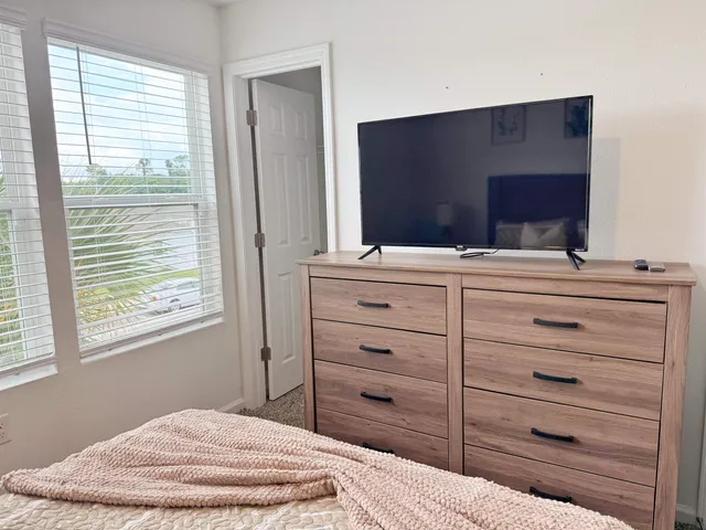 a bedroom with a bed and a flat screen tv