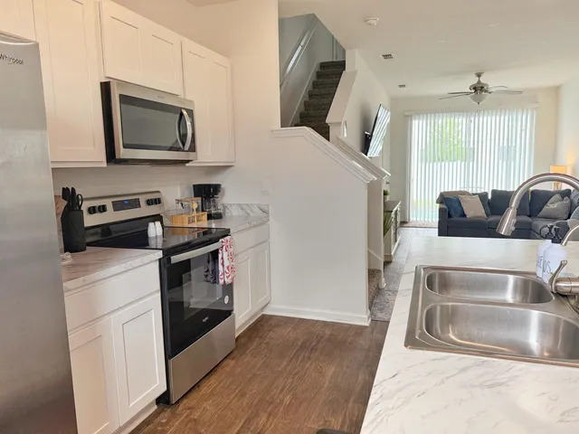 a kitchen with stainless steel appliances granite countertop a sink a stove and a refrigerator