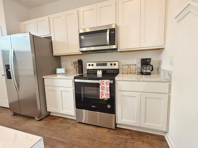 a kitchen with stainless steel appliances a stove a microwave sink and cabinets