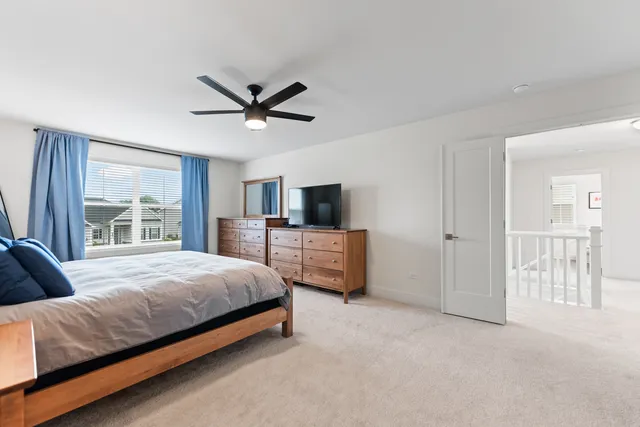 a bedroom with a bed a desk and a window