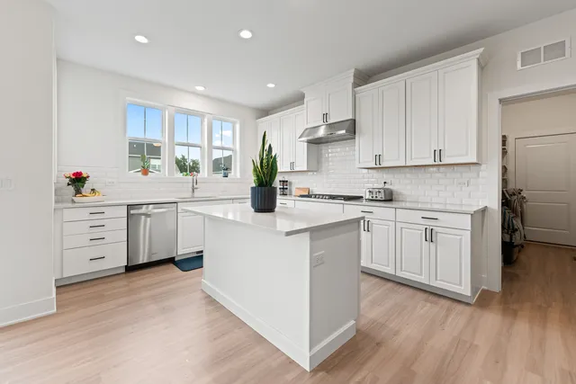 a kitchen with white cabinets and white appliances