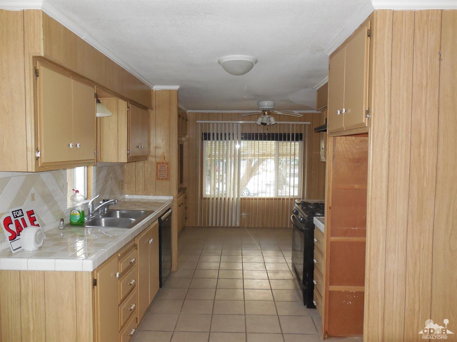 16820 Sunrise Road Desert Hot Springs, CA 92241 - Photo 5 of 19 a kitchen with a sink a refrigerator and window