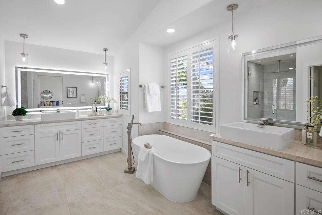 6160 Paseo Tapajos Carlsbad, CA 92009 - Photo 25 of 28 a spacious bathroom with a double vanity sink a bathtub a mirror and vanity