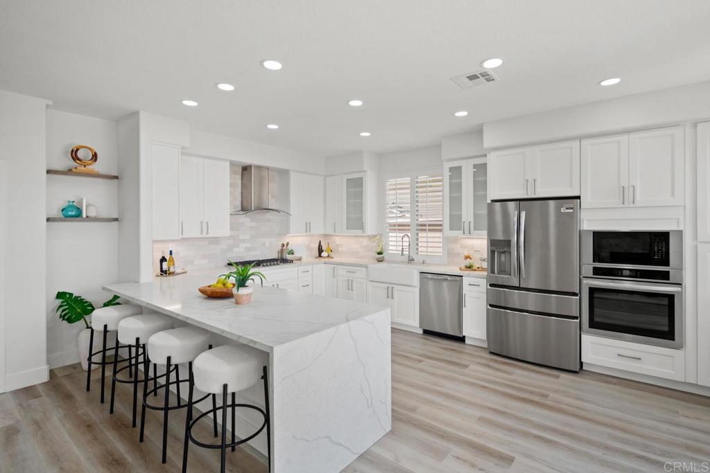 6160 Paseo Tapajos Carlsbad, CA 92009 - Photo 10 of 28 a kitchen with kitchen island white cabinets and stainless steel appliances