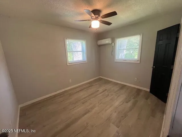an empty room with a window and a fan