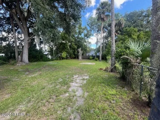 a view of a grassy field with trees in the background