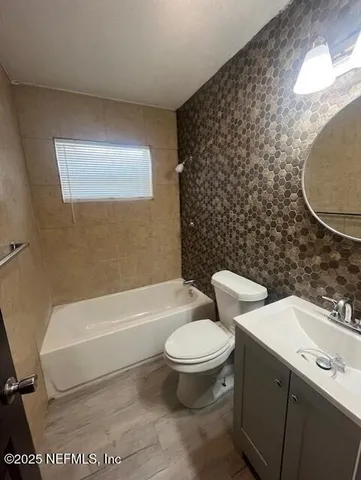 a white toilet sitting next to a bathroom sink and a tub