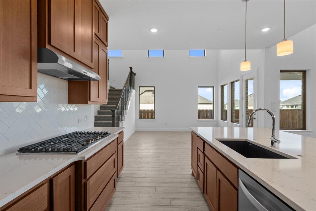 937 Mumms Drive Justin, TX 76247 - Photo 5 of 26 a kitchen with stainless steel appliances a sink a stove top oven a counter space and cabinets