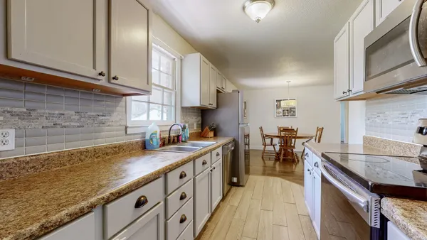 a kitchen with stainless steel appliances granite countertop a sink stove and cabinets