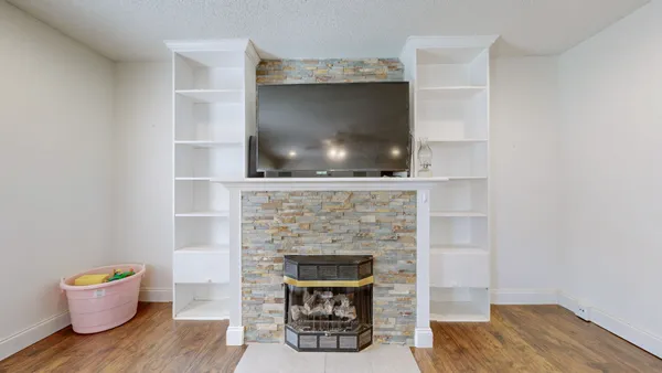 a living room with a fireplace and a wooden floor