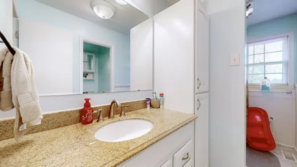 a bathroom with a granite countertop sink and a mirror