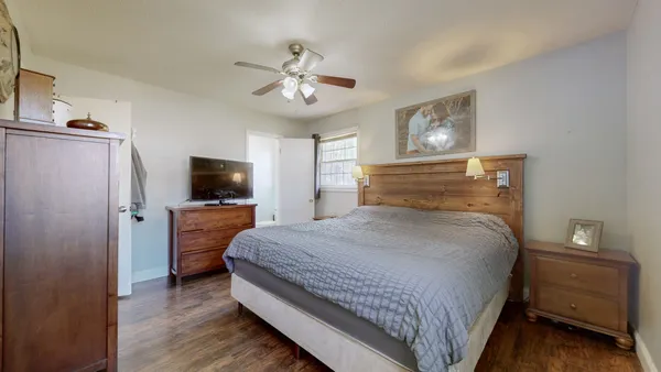 a bedroom with a bed and a tv on the dresser