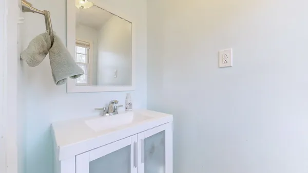 a bathroom with a sink vanity and a mirror