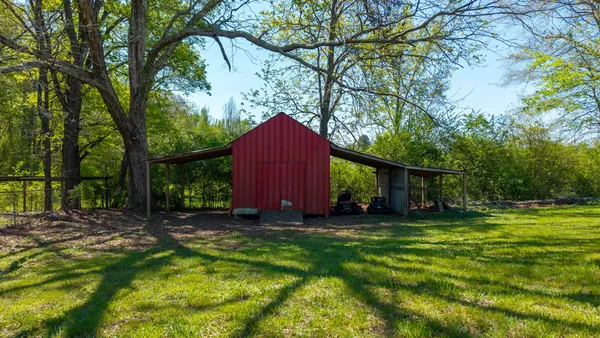 a view of a backyard with a small cabin and a chair