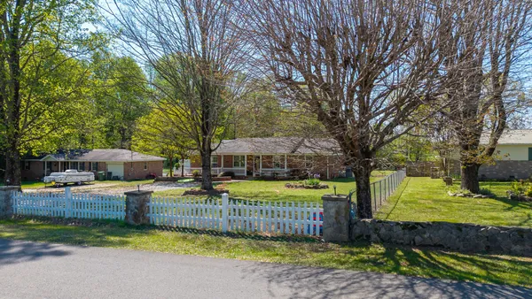 a view of a house with garden and trees