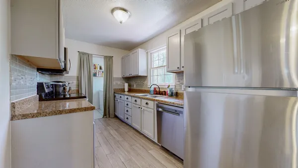 a kitchen with stainless steel appliances granite countertop a refrigerator a stove and a sink
