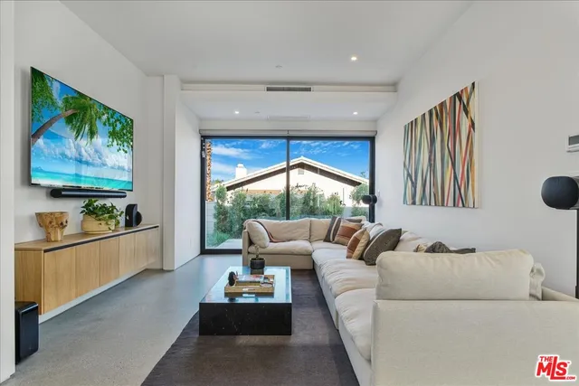 a living room with furniture and a floor to ceiling window