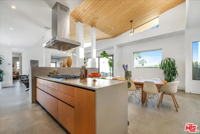 a living room with stainless steel appliances kitchen island granite countertop furniture and a dining table