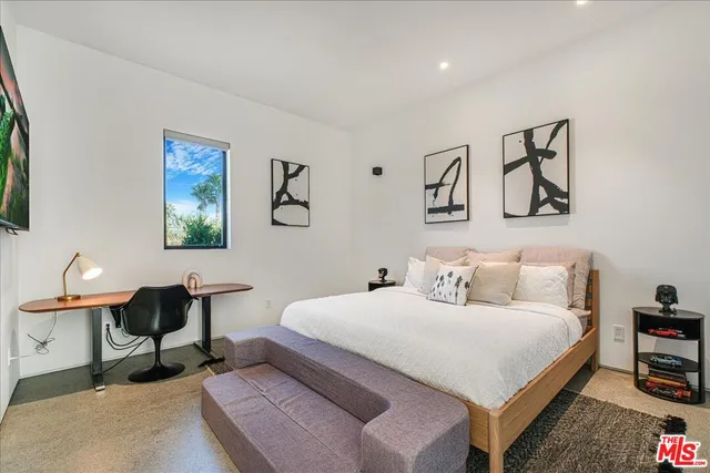 a bedroom with a bed a table and chair